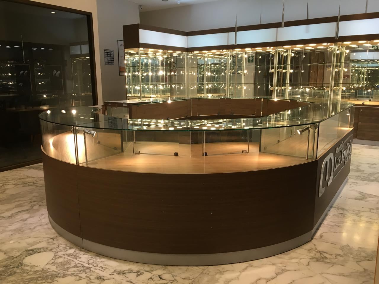 Mostrador curvo de joyería con cubierta de cristal e iluminación, fabricado por MODEC