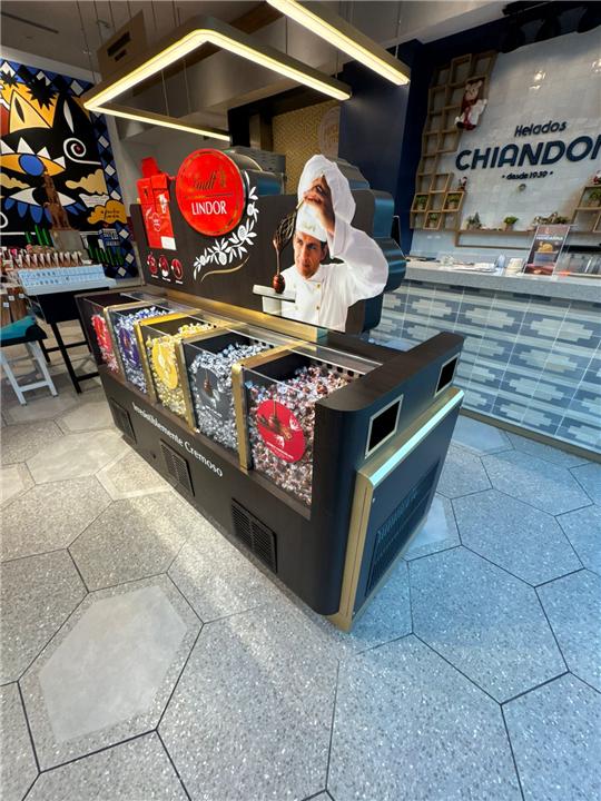 Isla central en negro con detalles dorados para chocolatería