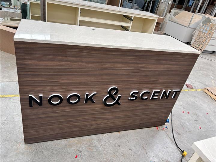 Mostrador con frente de madera y letras corpóreas del logotipo