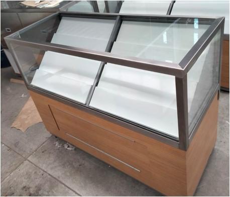 Vitrina mostrador de cristal con base de madera, vista de frente